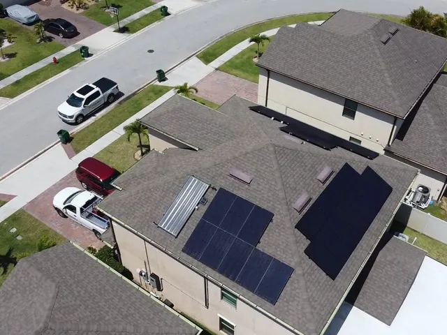 Aerial view of a street of houses with solar water heating on one roof