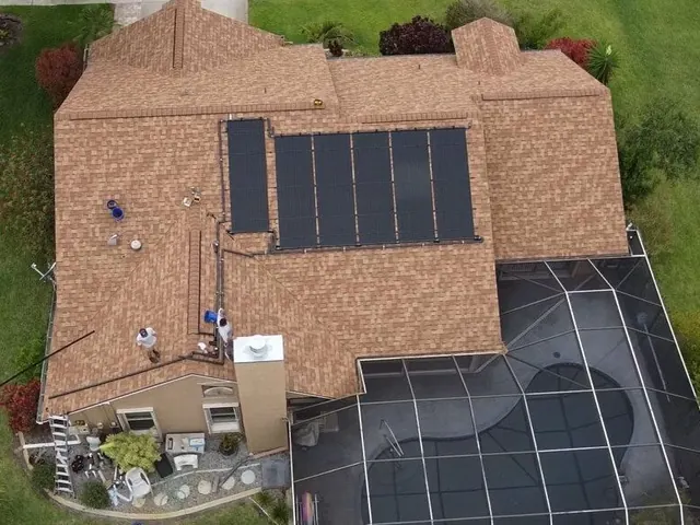 Aerial view of a home with solar water heating panels on the roof