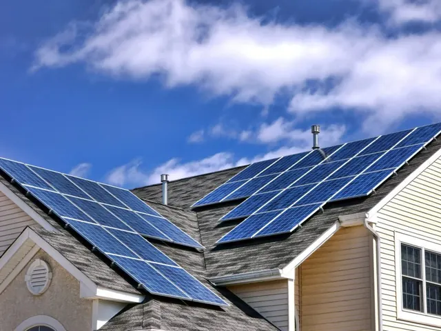 Two-storey house with solar panels on the roof under a blue sky