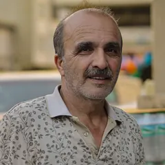Portrait of a smiling man with a grey moustache