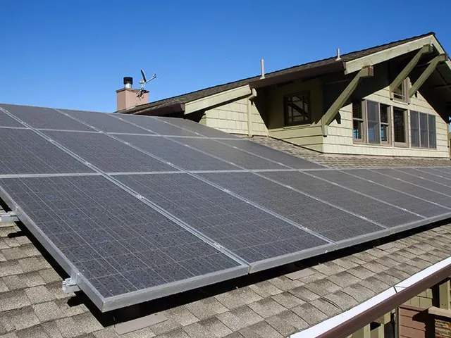 Solar panels on the grey shingle roof of a craftsman style house